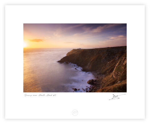 Sunrise light on the cliffs and lighthouse at Howth Head overlooking the Irish Sea, Dublin.