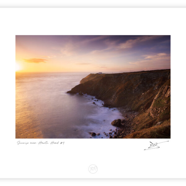 Sunrise light on the cliffs and lighthouse at Howth Head overlooking the Irish Sea, Dublin.