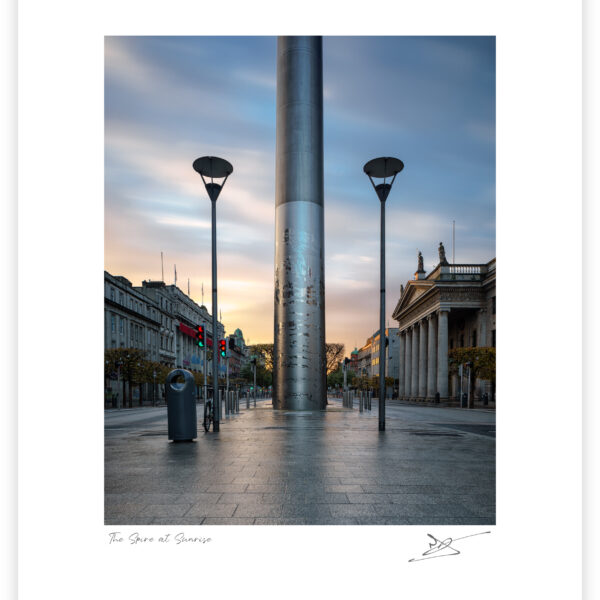The Spire of Dublin at sunrise on O’Connell Street, viewed straight on with soft morning light and empty streets.