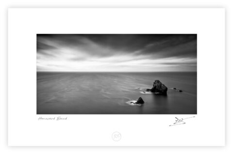 Sea stacks in shallow water at Caher Cove on the Copper Coast in County Waterford.