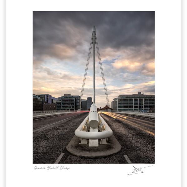 Samuel Beckett Bridge in Dublin seen head-on at dusk with long-exposure car light trails and dramatic clouds.