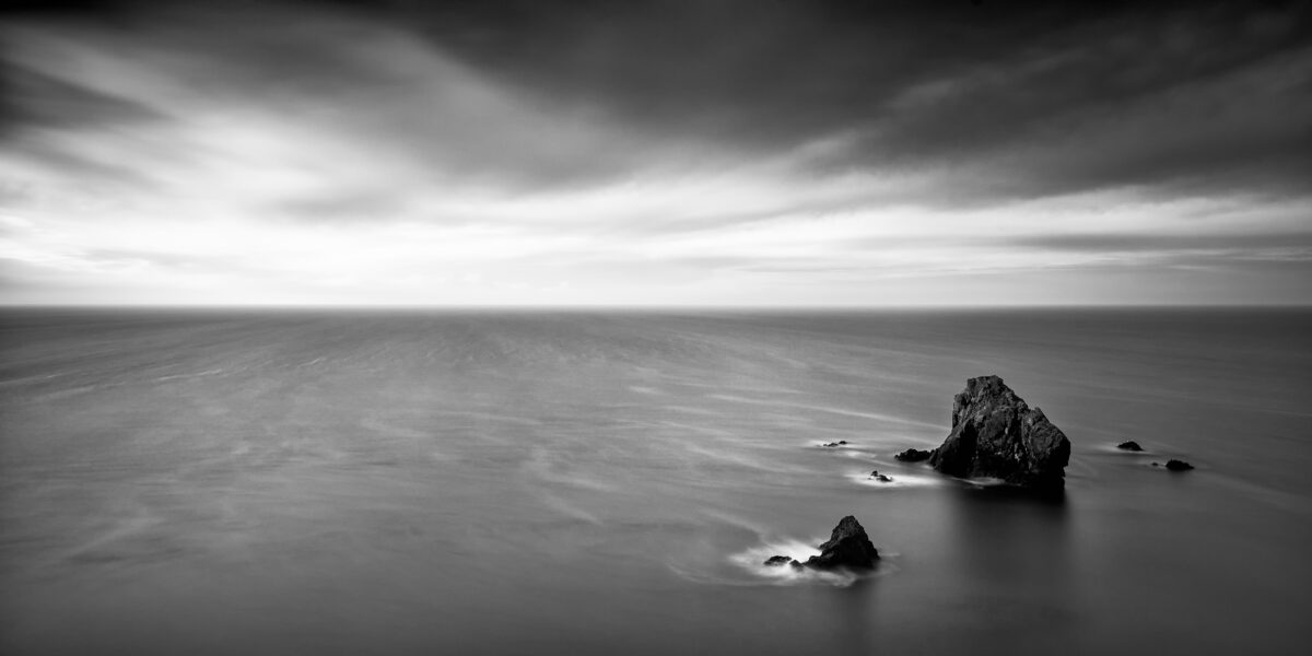Homeward Bound Sea stacks in shallow water at Caher Cove on the Copper Coast in County Waterford.