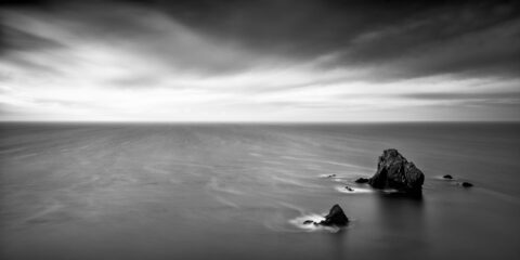 Sea stacks in shallow water at Caher Cove on the Copper Coast in County Waterford.
