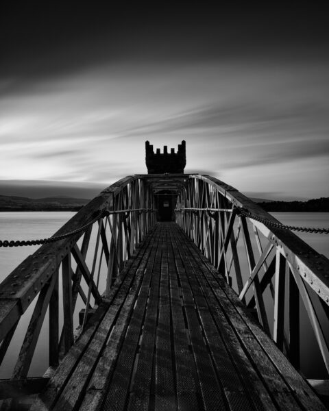 Bridge leading to the tower at Vartry Reservoir under dark clouds, County Wicklow, Ireland.