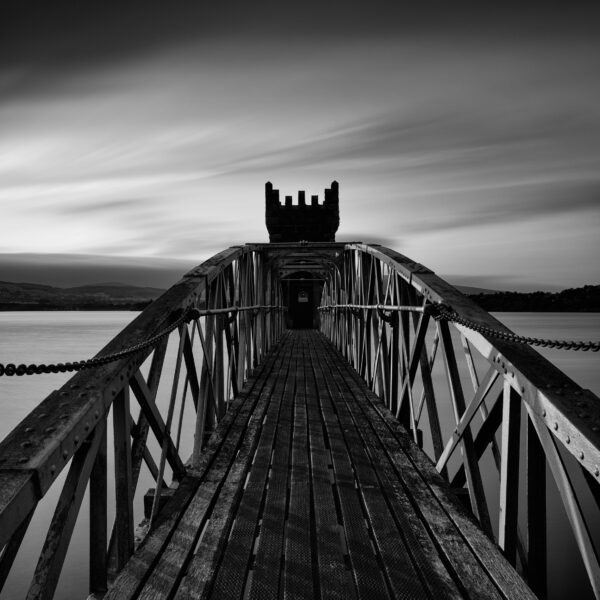 Bridge leading to the tower at Vartry Reservoir under dark clouds, County Wicklow, Ireland.