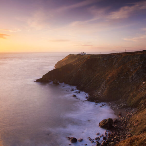 Sunrise light on the cliffs and lighthouse at Howth Head overlooking the Irish Sea, Dublin.