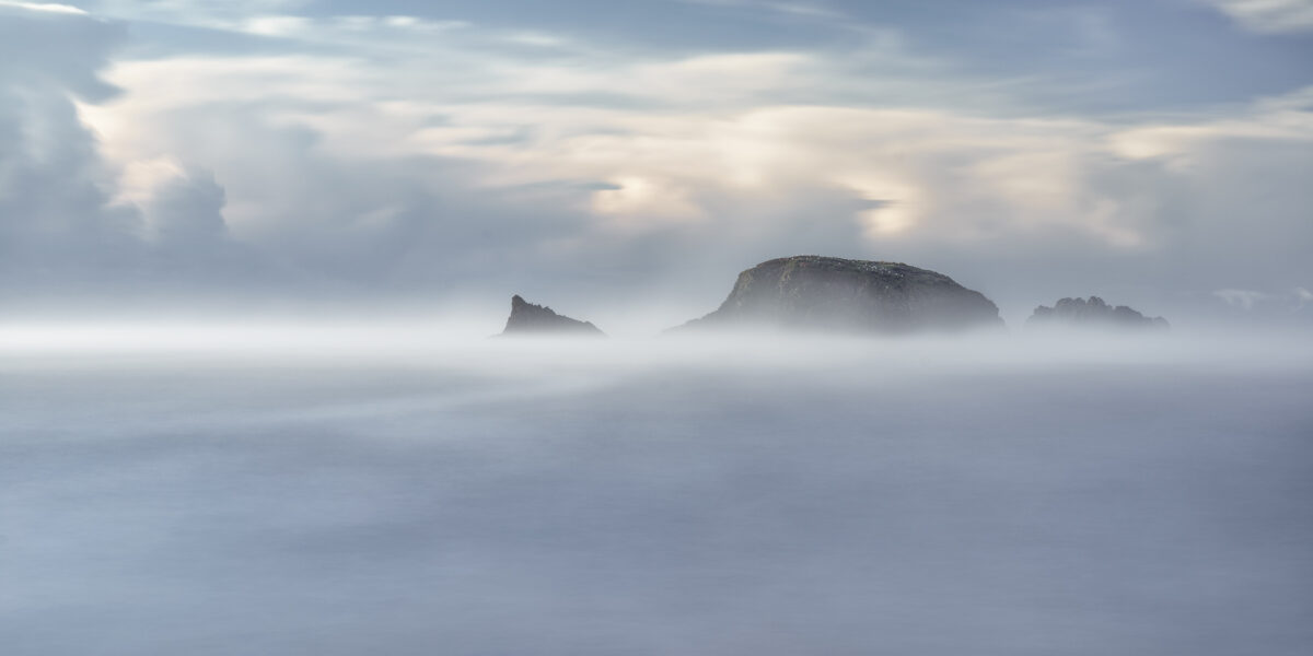 The Land that Time Forgot Sea mist partially obscuring Burke’s Island at Kilfarrasy Cove on the Copper Coast in County Waterford.