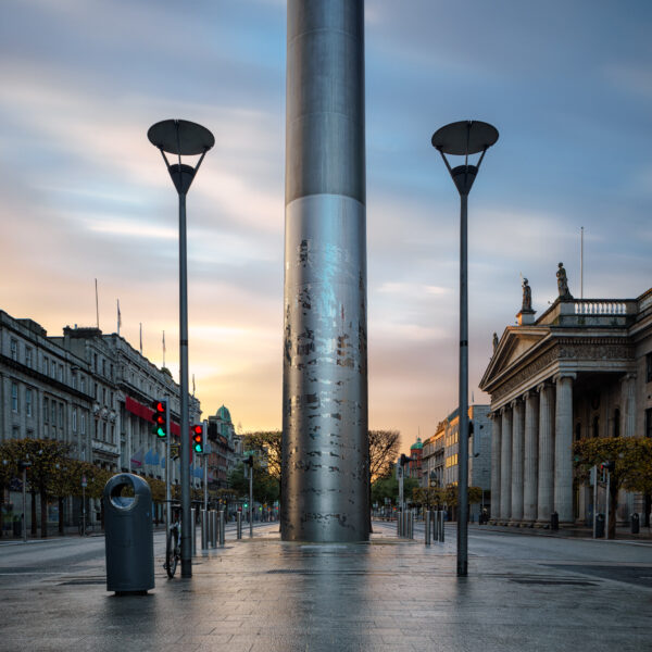 The Spire of Dublin at sunrise on O’Connell Street, viewed straight on with soft morning light and empty streets.