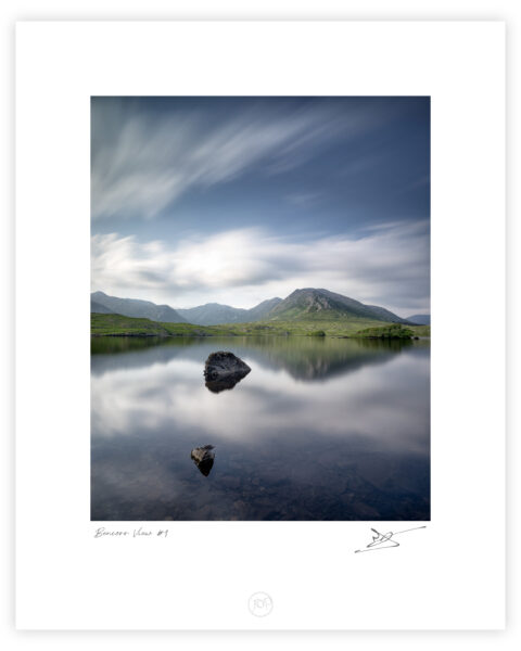 Mount Bencorr and the Twelve Pins reflected in calm water at Derryclare Lough in Connemara, Galway, Ireland, colour photograph.