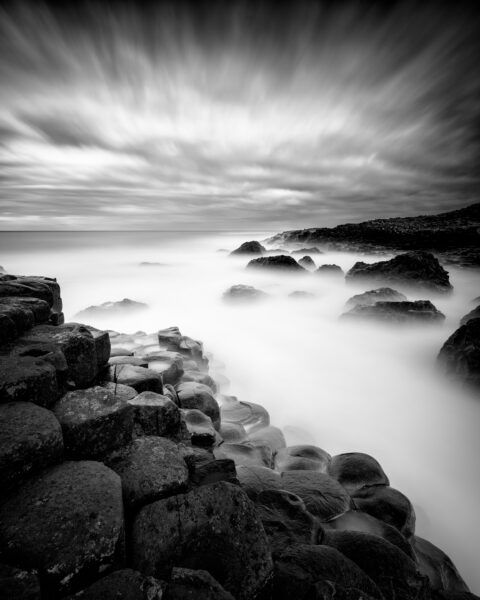 Basalt columns of the Giant’s Causeway with waves blurred by long exposure, County Antrim, Northern Ireland.