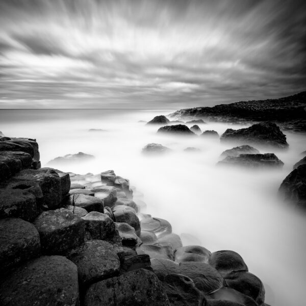 Basalt columns of the Giant’s Causeway with waves blurred by long exposure, County Antrim, Northern Ireland.