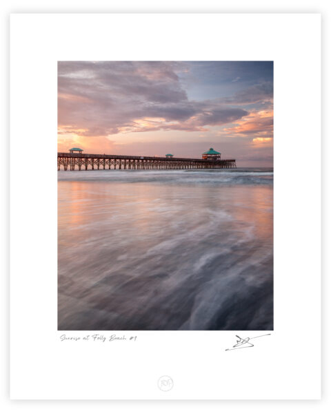 Folly Beach Fishing Pier at sunrise with soft waves and pastel sky in South Carolina, United States, colour photograph.