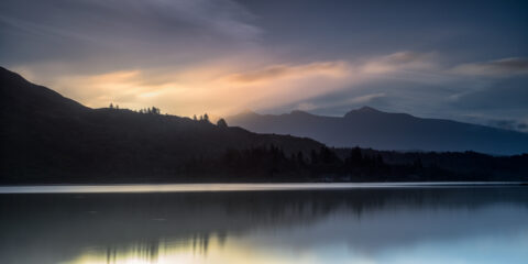Dawn light over Lough Caragh reflecting clouds beneath Carrauntoohil in County Kerry, Ireland.