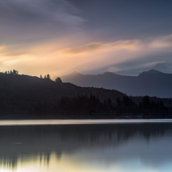 Dawn light over Lough Caragh reflecting clouds beneath Carrauntoohil in County Kerry, Ireland.