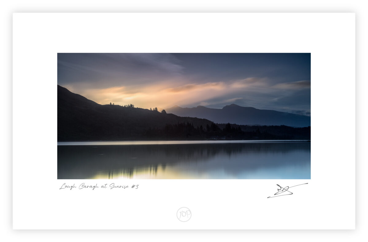Dawn light over Lough Caragh reflecting clouds beneath Carrauntoohil in County Kerry, Ireland.