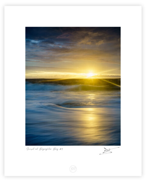 Sunset light breaking beneath clouds over the Atlantic at Murder Hole Beach on the Rosguill Peninsula in Donegal, Ireland, colour photograph.