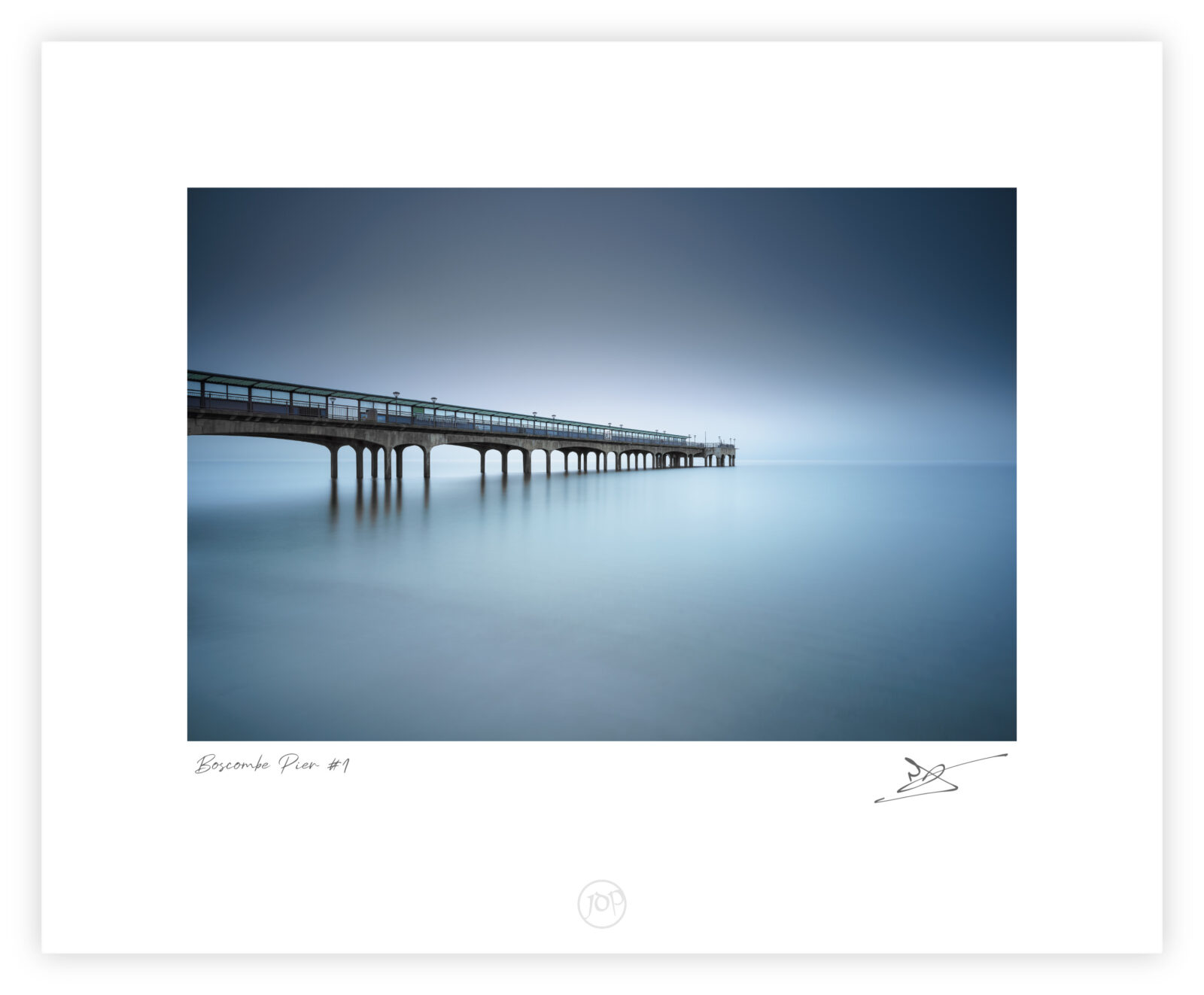 Boscombe Pier extending into a foggy sea at dawn in Bournemouth, England, colour photograph.