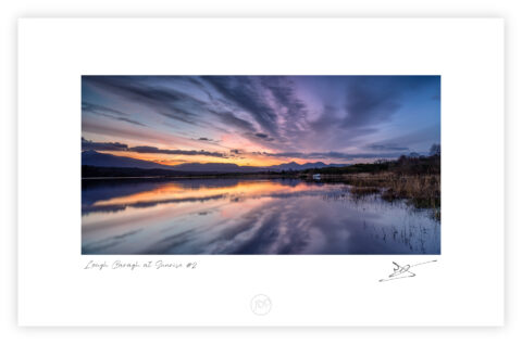 Sunrise over Lough Caragh with reflected clouds and mountains in County Kerry, Ireland.