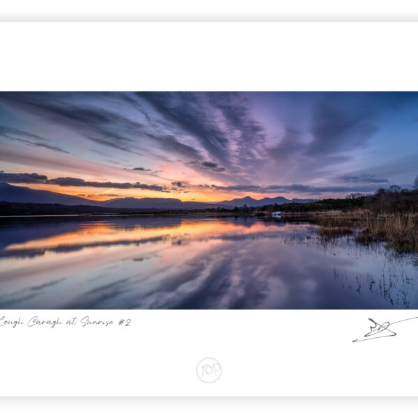 Sunrise over Lough Caragh with reflected clouds and mountains in County Kerry, Ireland.