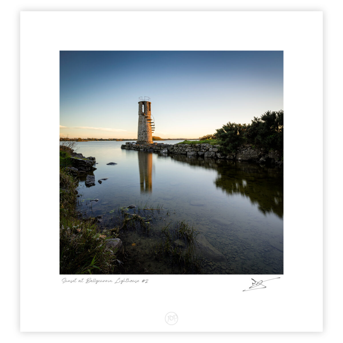 Ballycurrin Lighthouse reflected in calm water on Lough Corrib at sunset in Galway, Ireland, colour photograph.