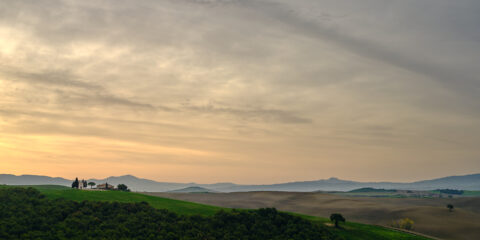 Cappella della Madonna di Vitaleta at sunrise with rolling Tuscan hills and soft clouds, Tuscany, Italy, colour photograph.
