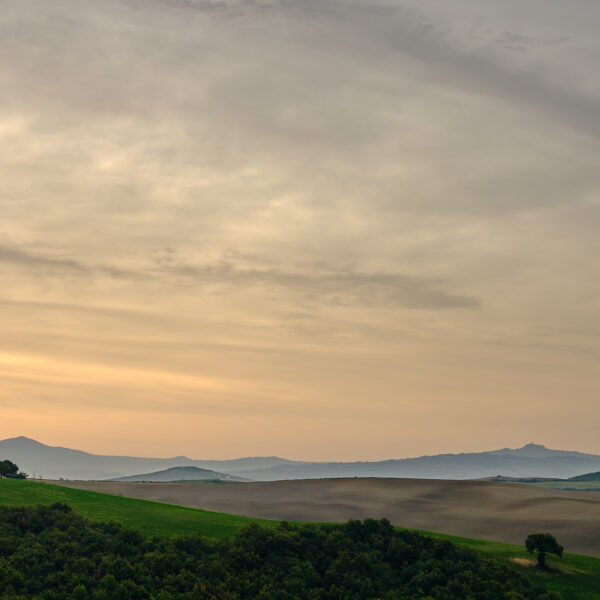 Cappella della Madonna di Vitaleta at sunrise with rolling Tuscan hills and soft clouds, Tuscany, Italy, colour photograph.