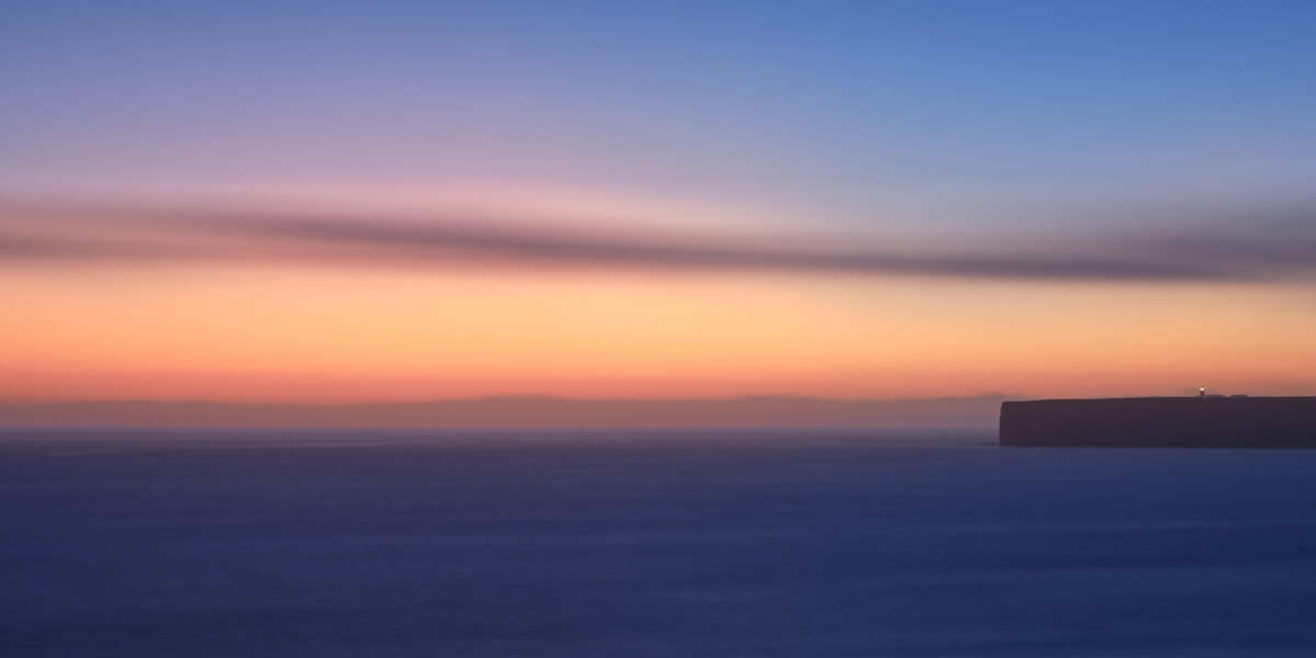 Sunset over Lighthouse of Cabo de São Vicente #1 - Calm, Quiet, Warm Sunset light behind Cabo de São Vicente Lighthouse in Sagres on the Algarve coast, colour photograph.