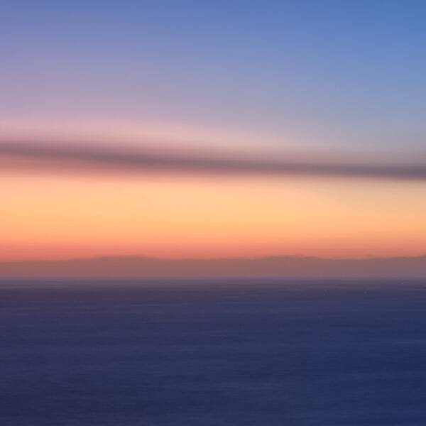 Sunset light behind Cabo de São Vicente Lighthouse in Sagres on the Algarve coast, colour photograph.