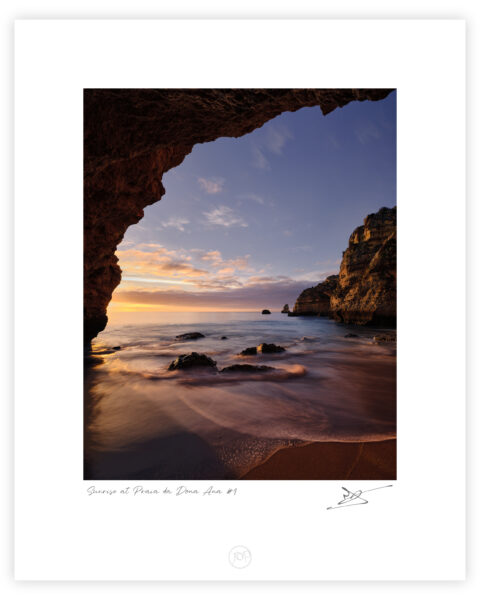 Sunrise light illuminating a sheltered cove at Praia da Dona Ana on the Algarve coast, colour photograph.