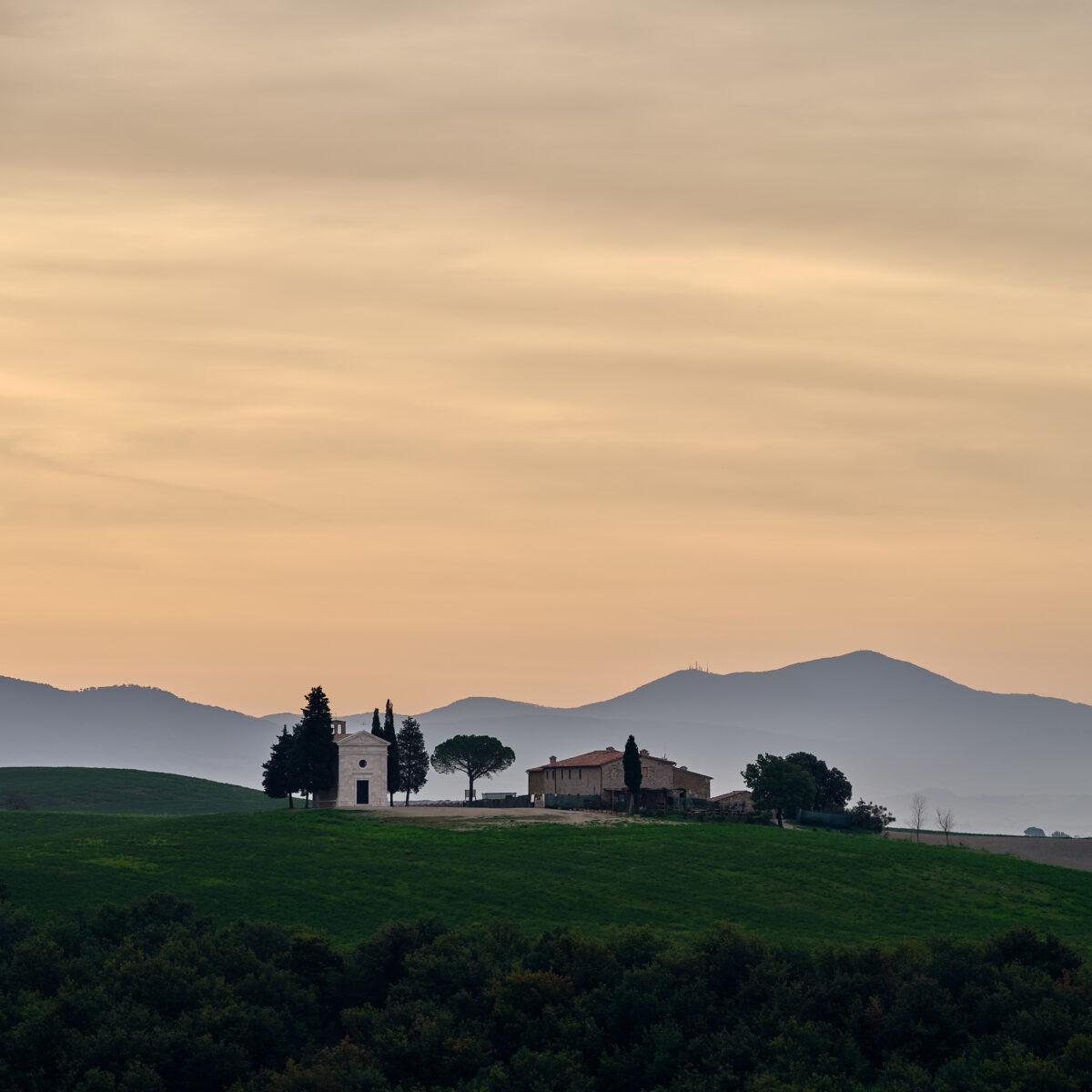 Sunrise at Cappella della Madonna di Vitaleta #2 - Pastel, Quiet, Warm Cappella della Madonna di Vitaleta at sunrise with rolling hills in Tuscany, Italy, colour photograph.