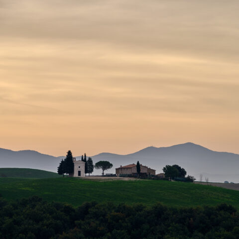 Cappella della Madonna di Vitaleta at sunrise with rolling hills in Tuscany, Italy, colour photograph.