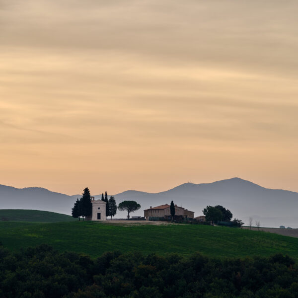 Cappella della Madonna di Vitaleta at sunrise with rolling hills in Tuscany, Italy, colour photograph.