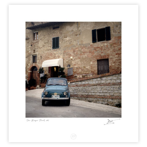 Vintage Fiat 500 parked beside stone buildings near San Biagio in Montepulciano, Italy, colour photograph.