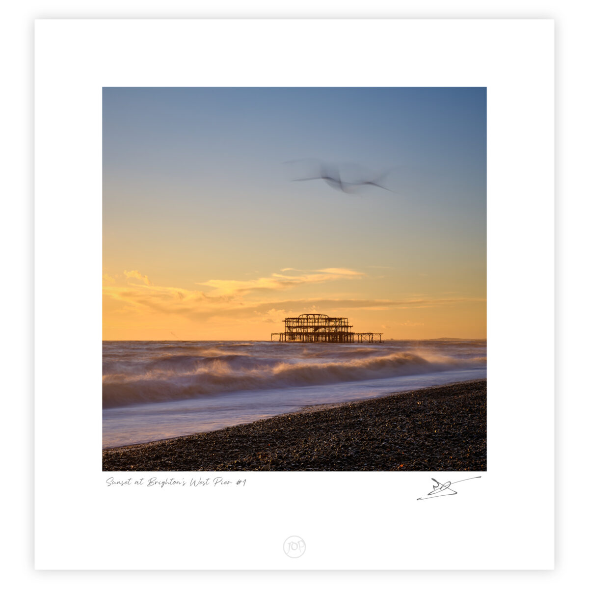 Waves breaking at sunset with the ruined West Pier offshore on Brighton beach, England, colour photograph.