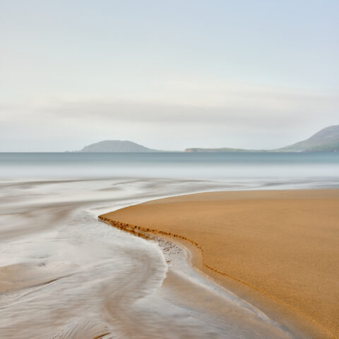 Long exposure of a sand bank and receding water on Portsalon Beach, County Donegal, Ireland, colour photograph.