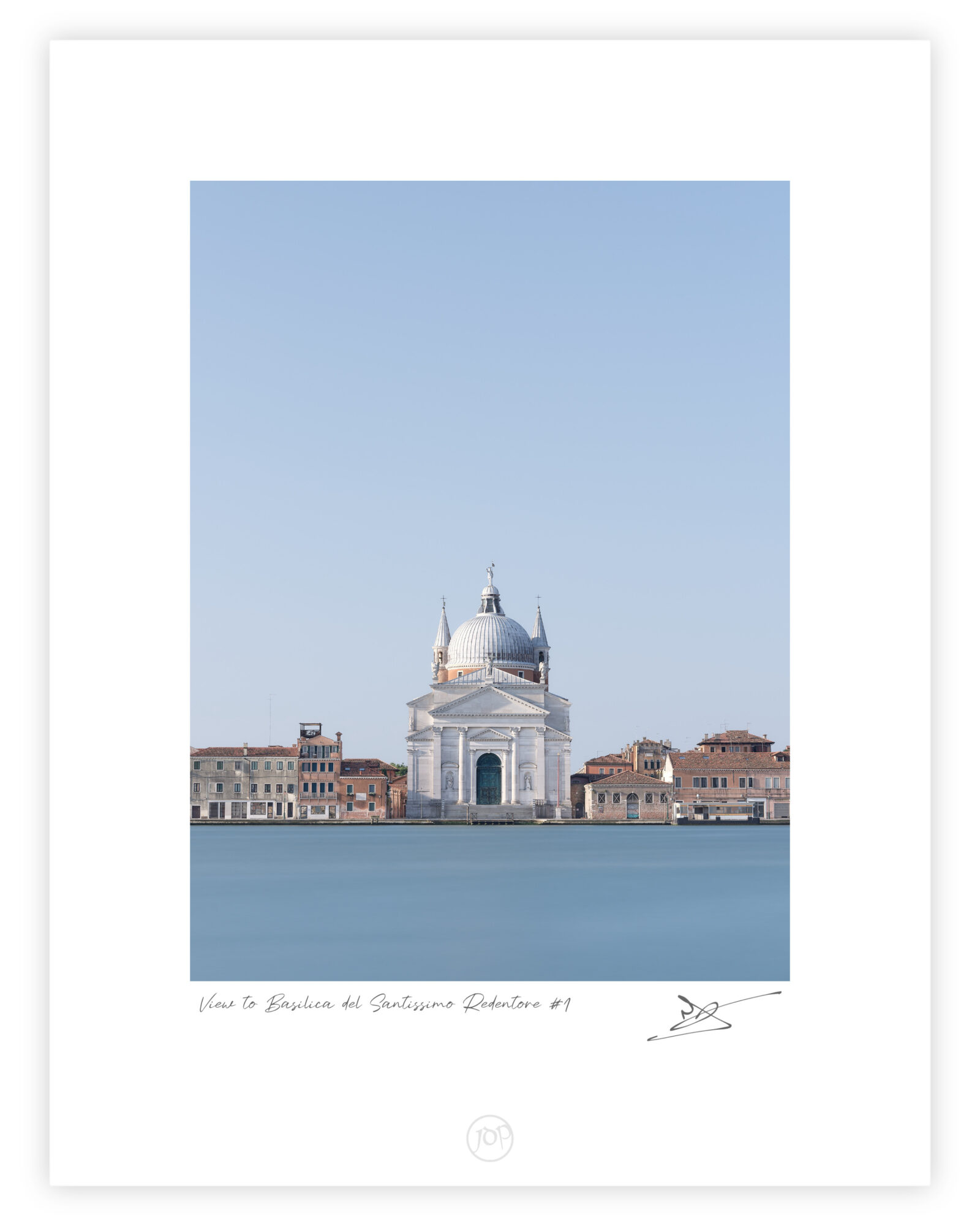 Centered view across smooth blue water to the white Basilica del Santissimo Redentore in Venice, framed by low terracotta-roofed buildings beneath a vast cloudless sky.